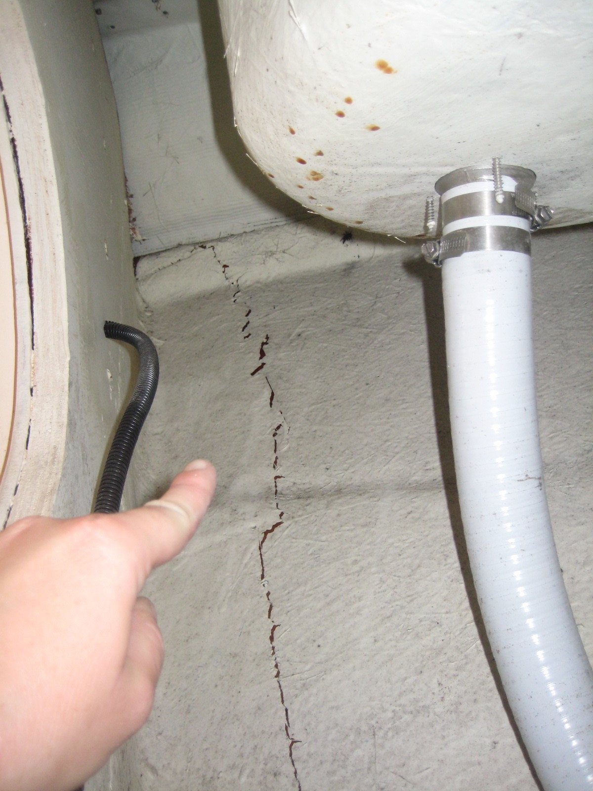 Surveyor pointing to area of delamination of vessel's fiberglass hull structure