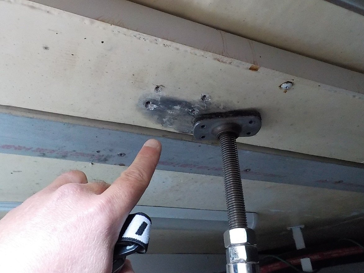 Surveyor pointing to detached support post below deck of boat