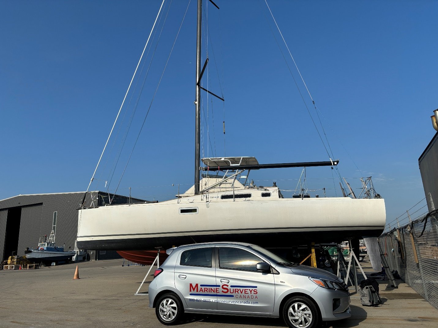 Marine Surveys Canada car in front of sailboat