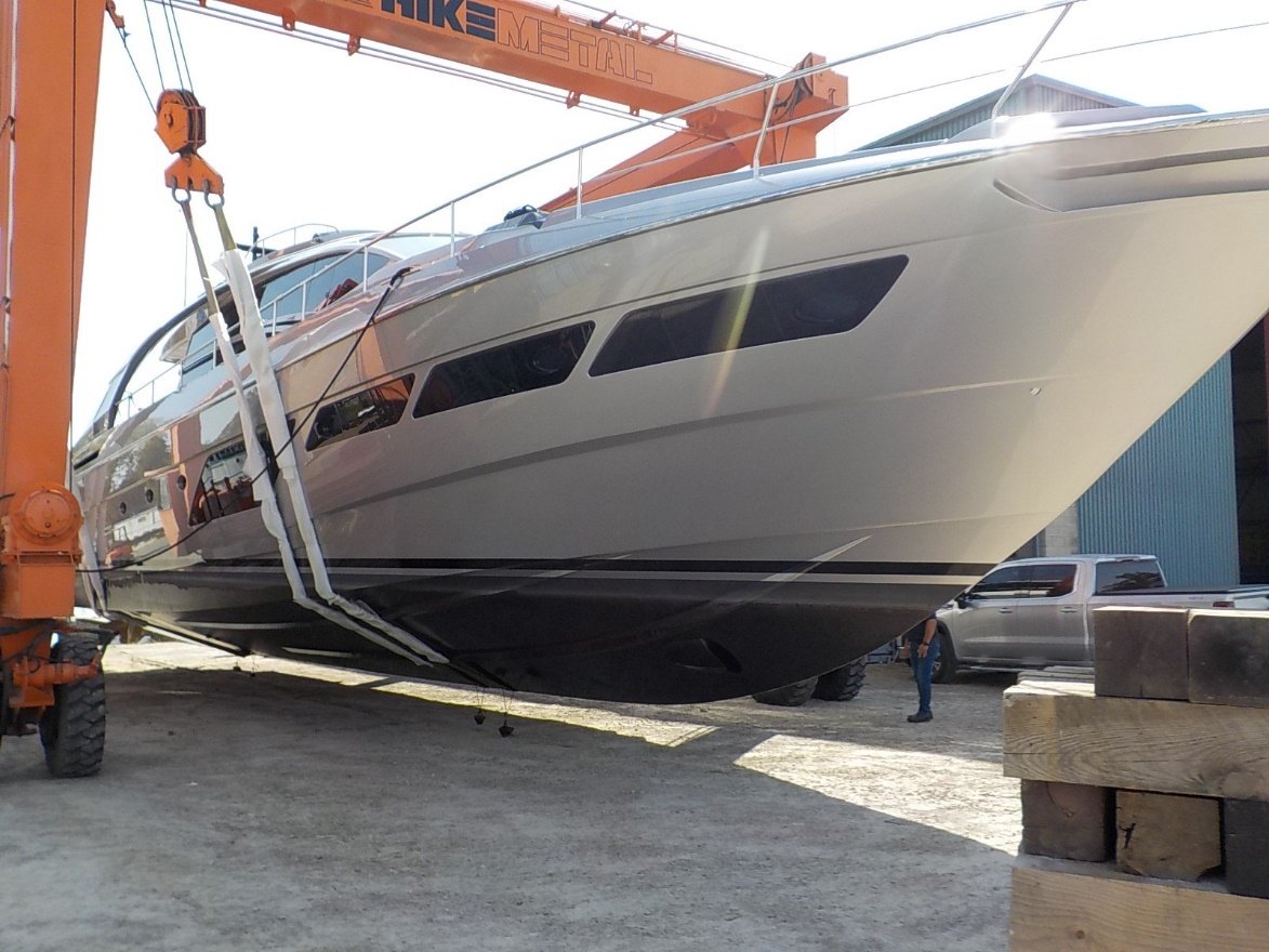 Yacht lifted out of water in travel lift slings